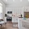 kitchen area with island, appliances, white cabinets and dining table